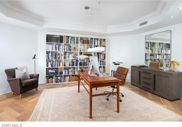 office space featuring light parquet floors, ornamental molding, and a tray ceiling