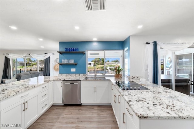 kitchen featuring visible vents, black electric stovetop, stainless steel dishwasher, and a peninsula