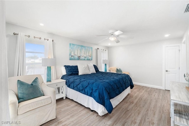 bedroom with ceiling fan, wood finished floors, visible vents, and baseboards