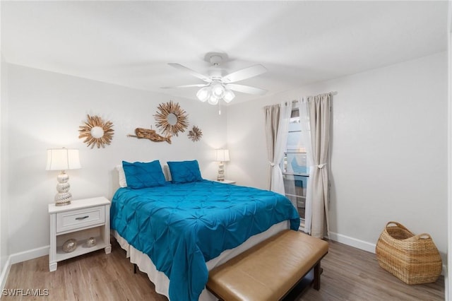 bedroom featuring a ceiling fan, wood finished floors, and baseboards