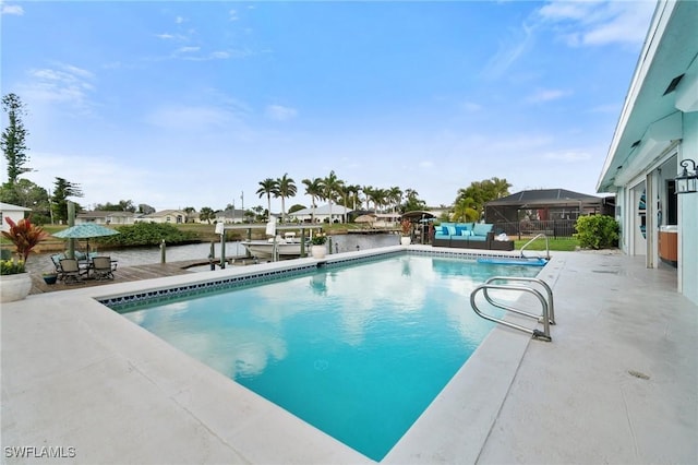 pool with a dock, a patio area, and fence