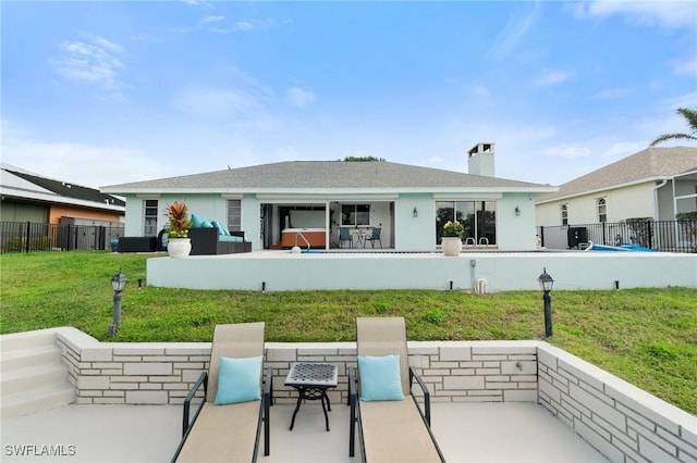 back of property with stucco siding, a lawn, a patio, and fence