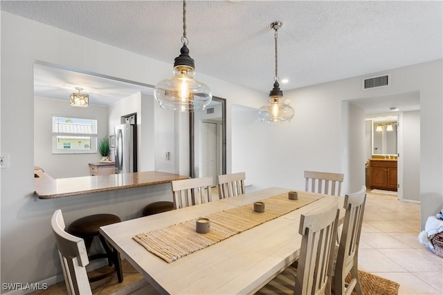 dining area with light tile patterned floors and a textured ceiling