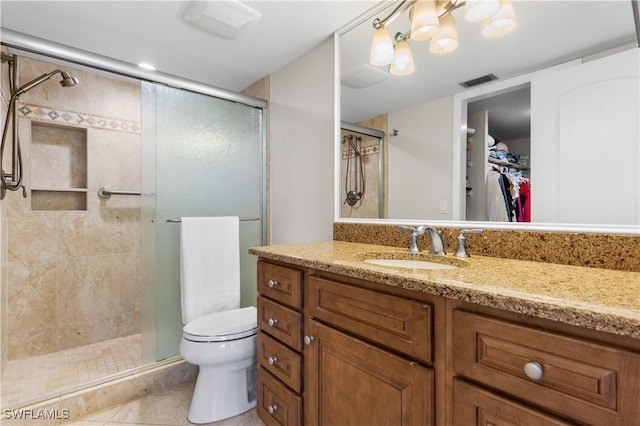 bathroom featuring vanity, toilet, tile patterned flooring, and a shower with door