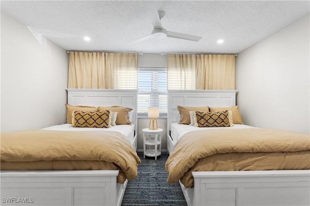 bedroom with ceiling fan, carpet floors, and a textured ceiling