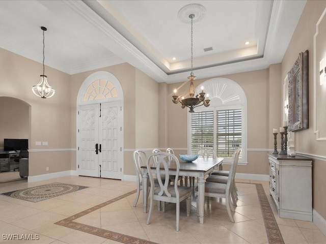 dining space featuring an inviting chandelier and a raised ceiling