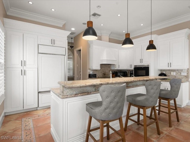 kitchen featuring premium range hood, white cabinetry, oven, and light stone countertops