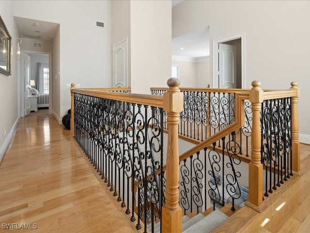 hallway featuring a towering ceiling and light hardwood / wood-style floors