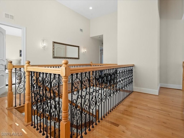 staircase with hardwood / wood-style floors and a high ceiling