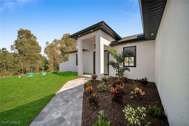 doorway to property featuring a lawn