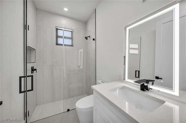 bathroom with vanity, a shower with shower door, toilet, and plenty of natural light