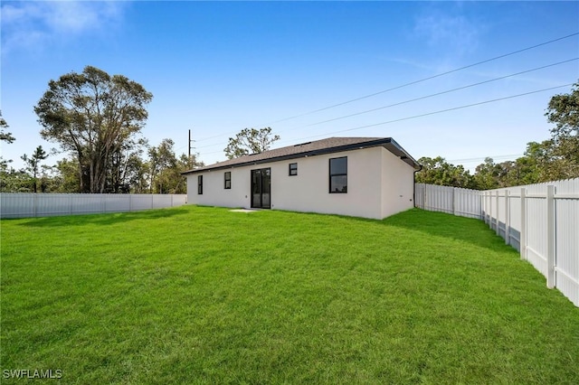 rear view of property with a lawn