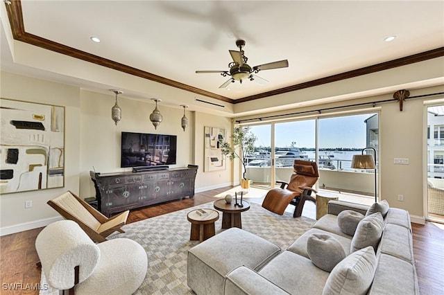 living room featuring a tray ceiling, ornamental molding, and dark hardwood / wood-style floors