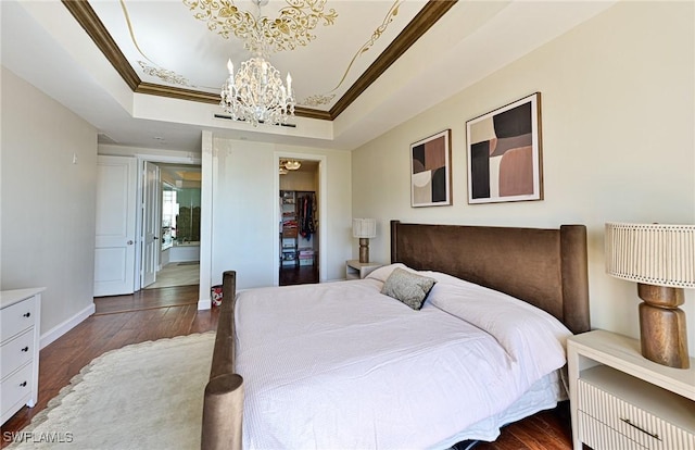 bedroom with a raised ceiling, crown molding, dark hardwood / wood-style floors, and a chandelier