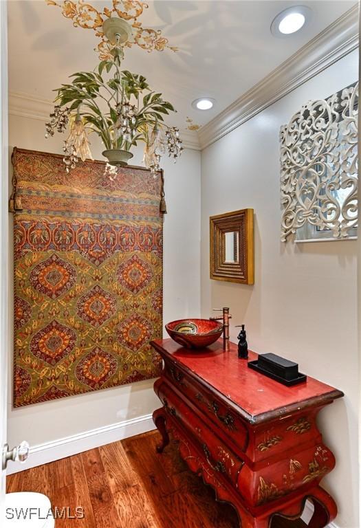 bathroom with ornamental molding and hardwood / wood-style floors