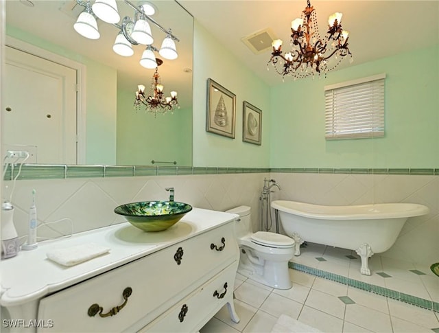 bathroom with an inviting chandelier, a bath, tile patterned flooring, and toilet