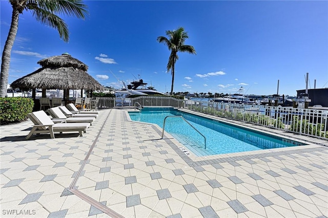 view of pool with a gazebo, a water view, and a patio