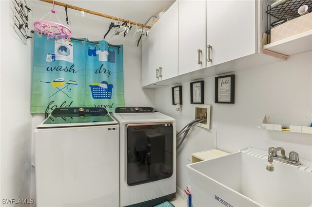 clothes washing area with cabinets, separate washer and dryer, and sink