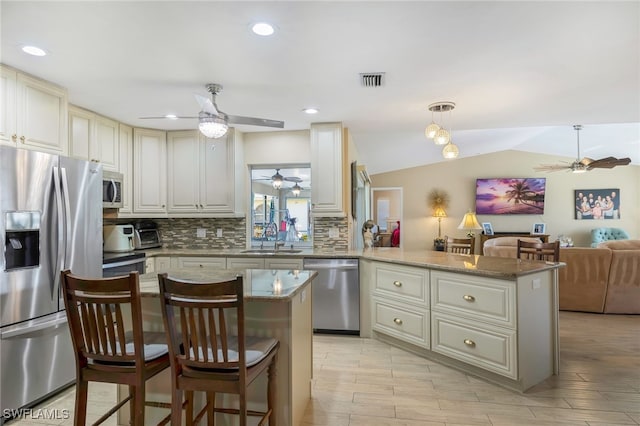 403 SE 28th Ter, Cape Coral, FL 33904 - kitchen featuring decorative backsplash, ceiling fan, stainless steel appliances, and a peninsula