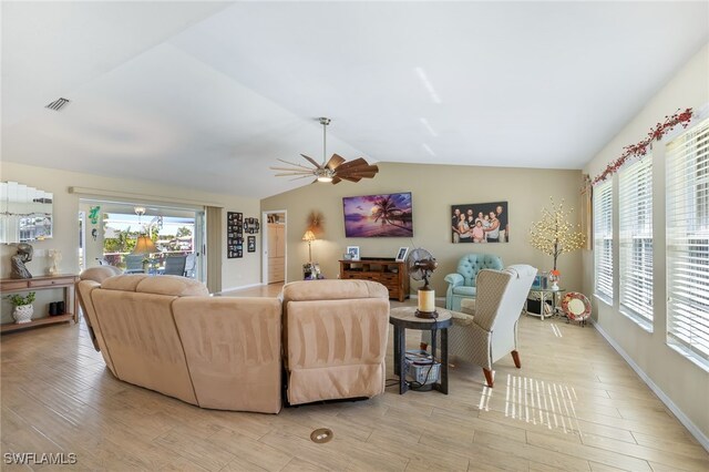 living room with ceiling fan, lofted ceiling, plenty of natural light, and light wood-type flooring