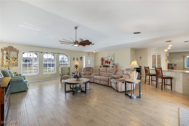 living room featuring vaulted ceiling, light hardwood / wood-style floors, and ceiling fan