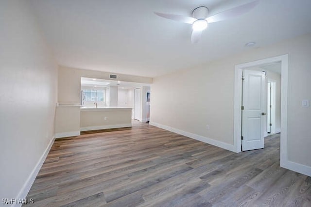 empty room featuring dark wood-type flooring and ceiling fan