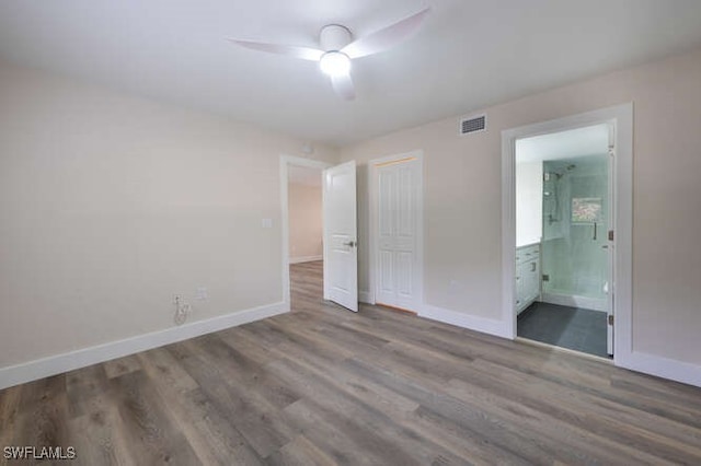 unfurnished bedroom featuring connected bathroom, hardwood / wood-style floors, a closet, and ceiling fan