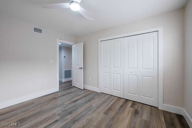 unfurnished bedroom with hardwood / wood-style floors, ceiling fan, and a closet