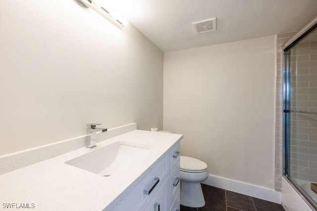 full bathroom featuring enclosed tub / shower combo, vanity, tile patterned floors, and toilet