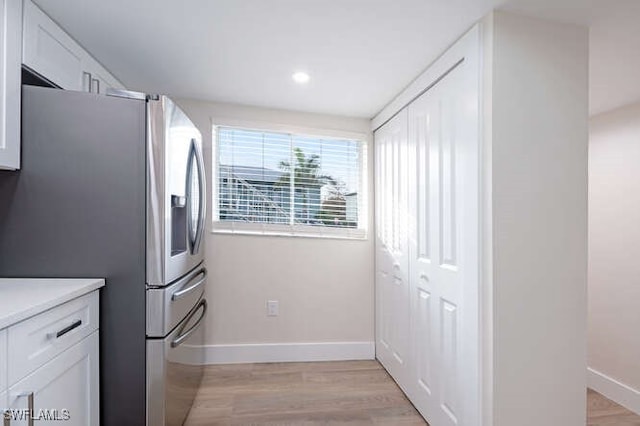 kitchen featuring white cabinetry, stainless steel fridge, and light wood-type flooring