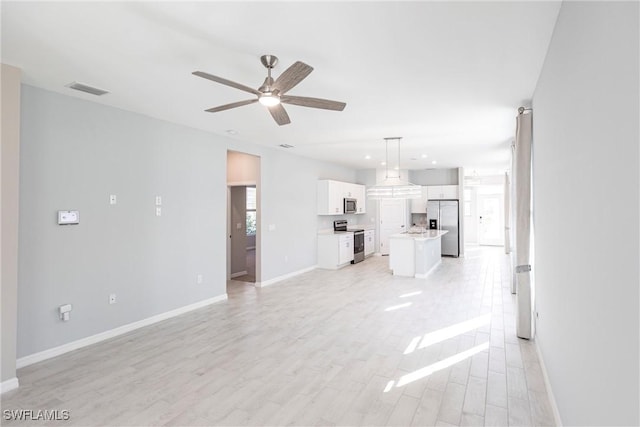 unfurnished living room featuring ceiling fan and light hardwood / wood-style flooring