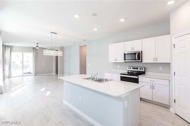 kitchen with white cabinetry, appliances with stainless steel finishes, sink, and a center island with sink