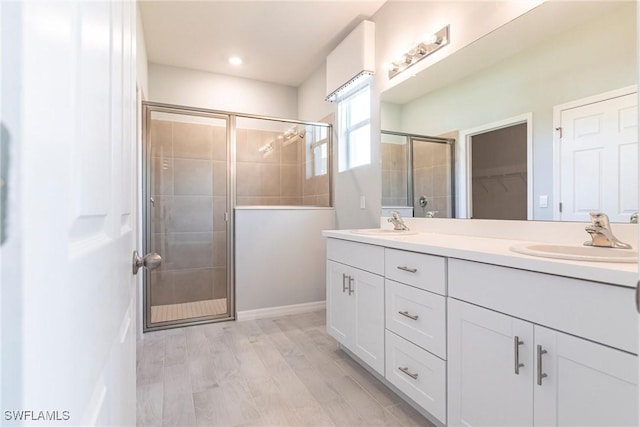 bathroom with a shower with door, vanity, and hardwood / wood-style floors