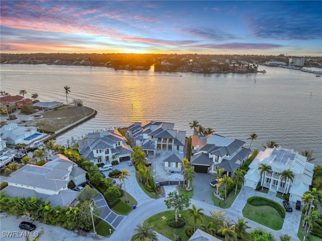 aerial view at dusk featuring a water view