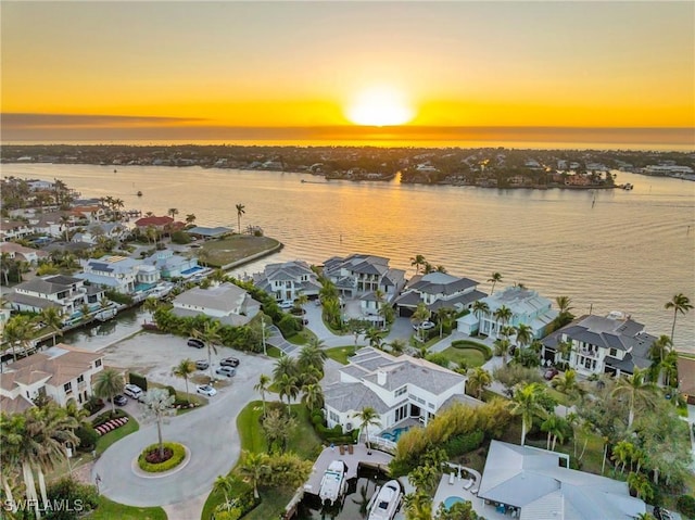 aerial view at dusk featuring a water view