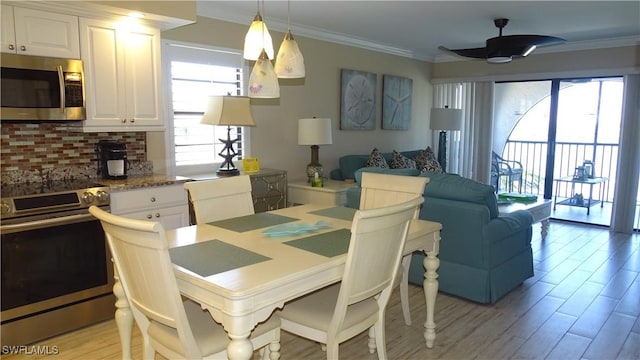 dining area with light hardwood / wood-style flooring, ornamental molding, and ceiling fan