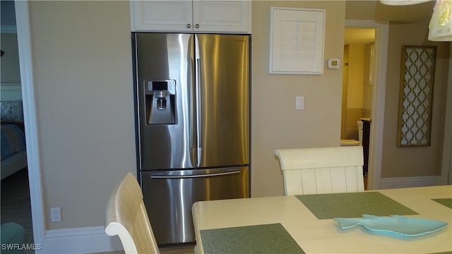 kitchen featuring white cabinetry and stainless steel refrigerator with ice dispenser