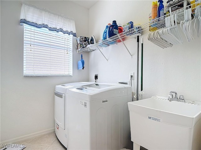 washroom featuring sink, light tile patterned floors, and washing machine and clothes dryer