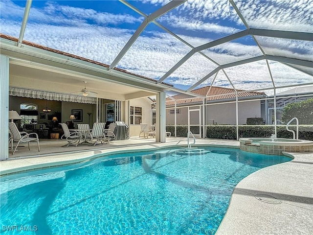 view of swimming pool featuring a patio, a lanai, an in ground hot tub, and ceiling fan