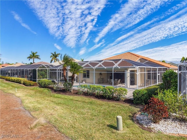 back of property featuring a lanai, a patio area, and a lawn