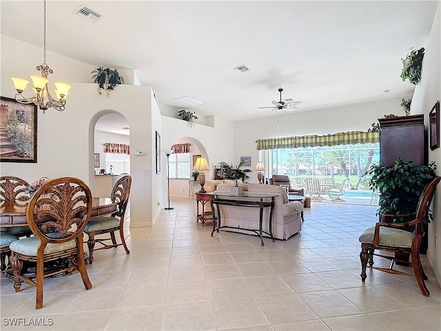 tiled living room with plenty of natural light and ceiling fan with notable chandelier