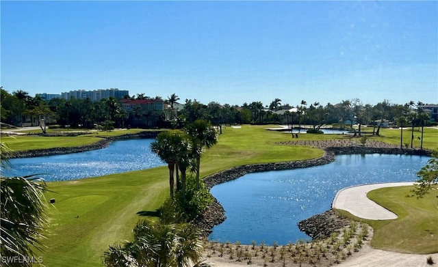 view of home's community with golf course view, a yard, and a water view