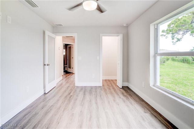 unfurnished bedroom with ceiling fan, multiple windows, and light hardwood / wood-style flooring