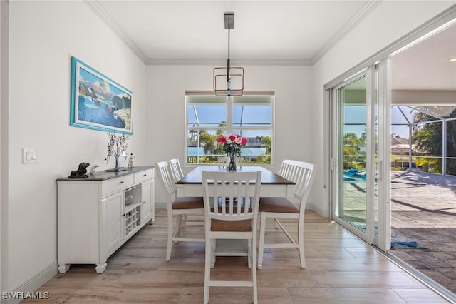 dining room with ornamental molding and light wood-type flooring