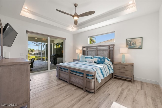 bedroom with a raised ceiling, access to outside, ceiling fan, and light hardwood / wood-style flooring