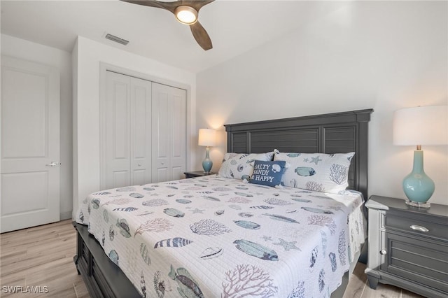 bedroom with ceiling fan, a closet, and light hardwood / wood-style flooring