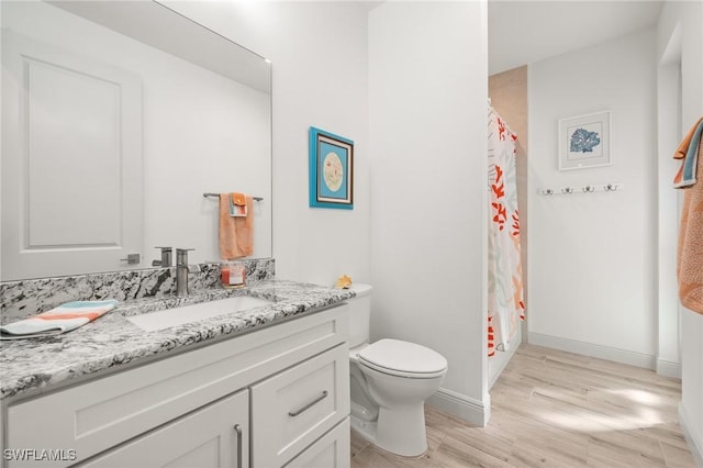 bathroom featuring vanity, hardwood / wood-style floors, curtained shower, and toilet