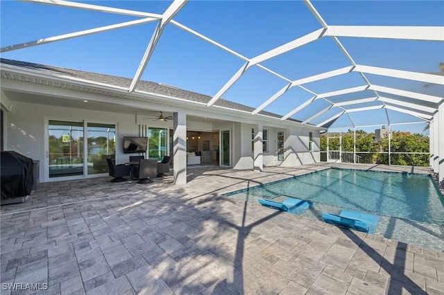 view of pool with ceiling fan, a lanai, and a patio area