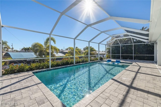 view of swimming pool with a patio area and glass enclosure