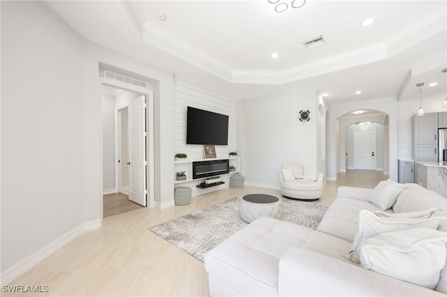 living room with crown molding and a raised ceiling